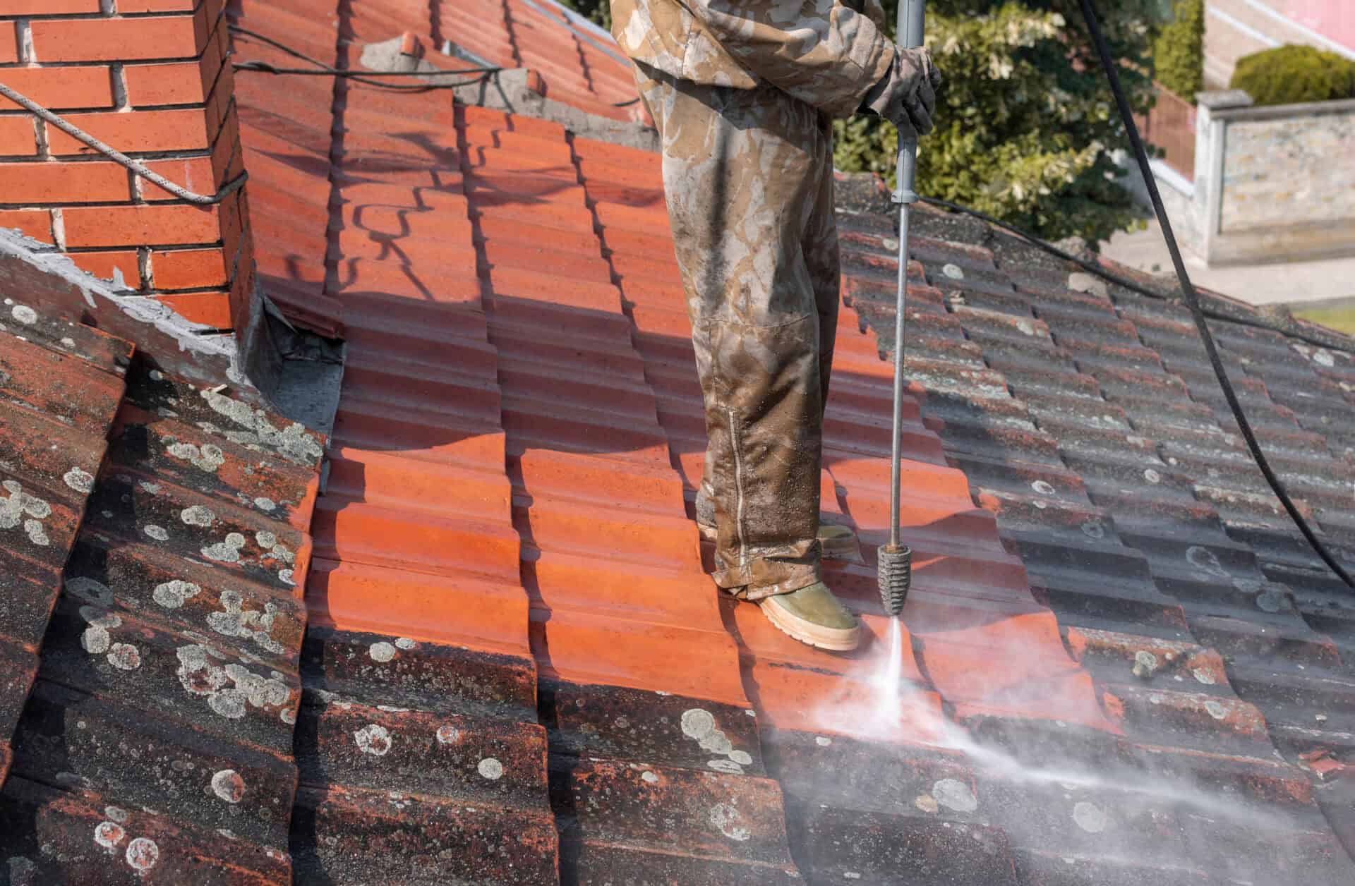State of roof before and after washing with high pressure. Profeessional is wearing uniform and using equipment for cleaning